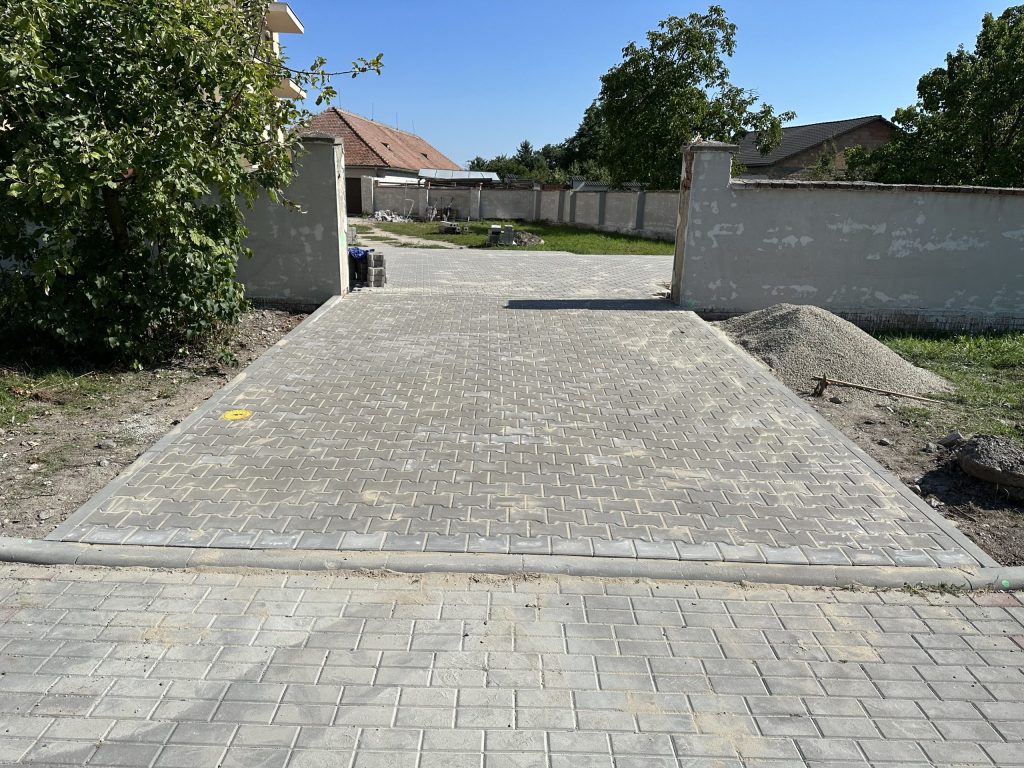 Nově dokončená zámkovka u vjezdu na pozemek, vedoucí k uzavřenému areálu.