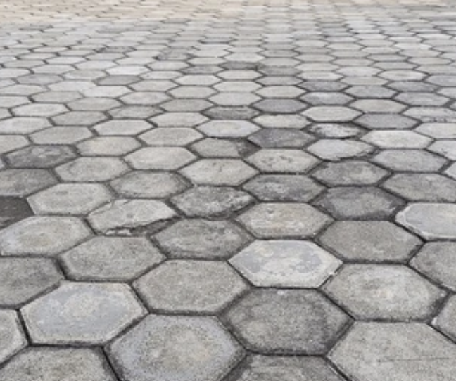 Šestihranná betonová dlažba v různých odstínech šedé s detailním pohledem na povrch.